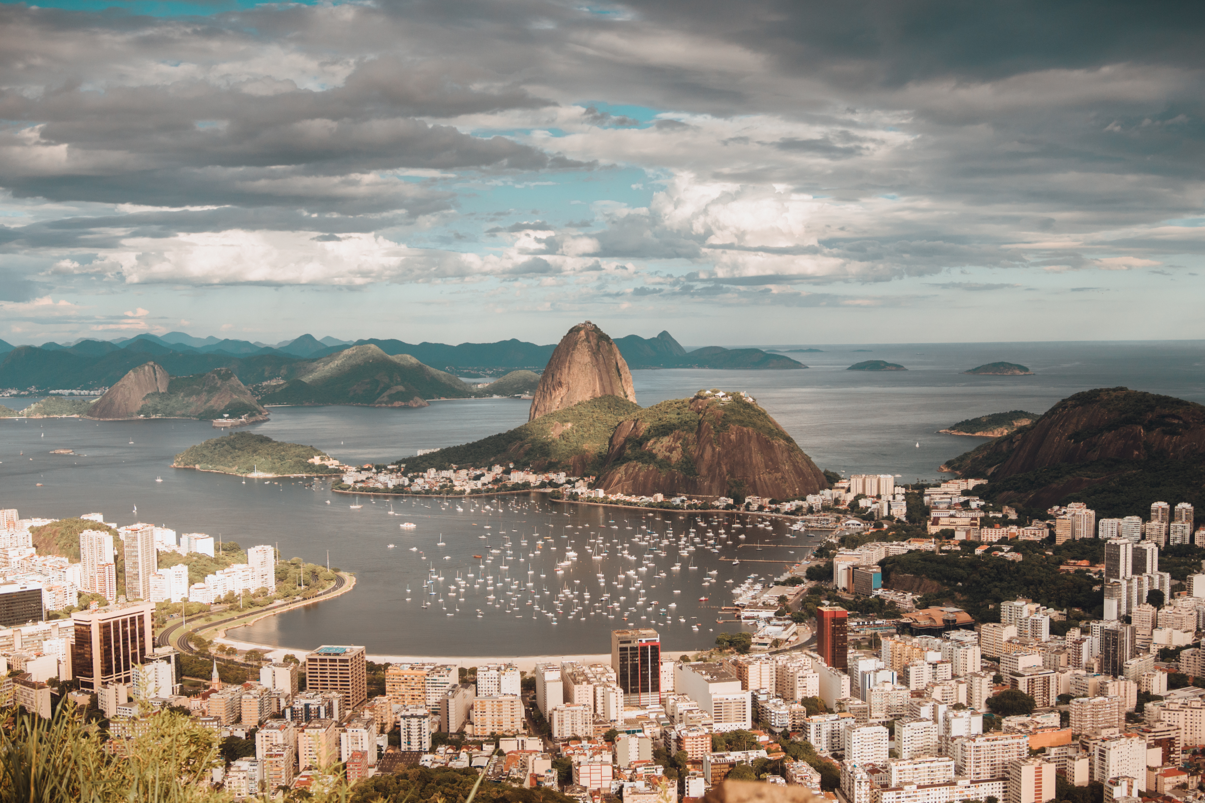 Vista aérea da Baía de Botafogo no Rio de Janeiro, com o Pão de Açúcar e a cidade ao redor.