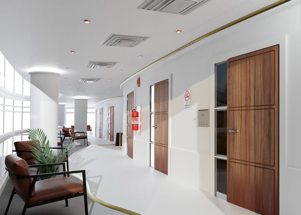 Um corredor moderno e curvo em um hospital ou clínica, com portas de madeira, um extintor de incêndio vermelho e cadeiras de espera marrons perto de grandes janelas.
